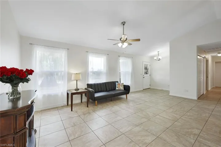 Living room with vaulted ceiling, and large square-format tile throughout.