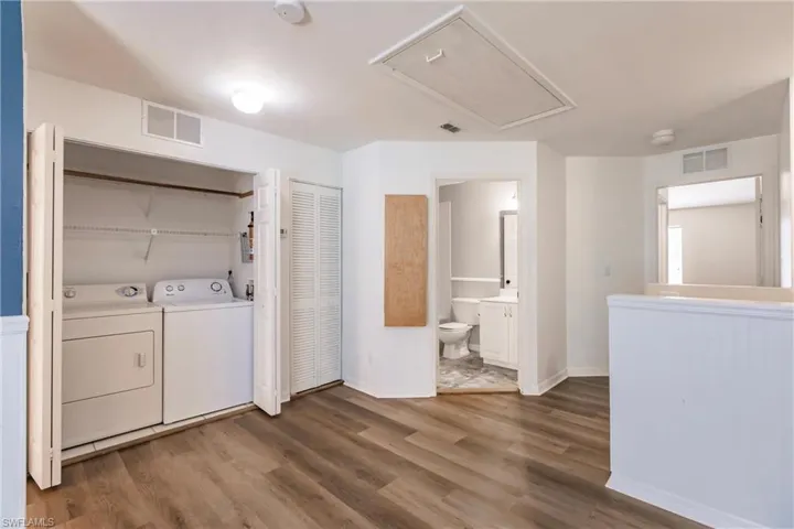 Laundry room featuring separate washer and dryer and wood-type flooring