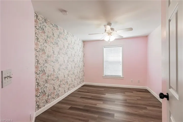 Spare room featuring dark hardwood / wood-style floors and ceiling fan