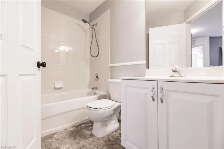 Full bathroom with toilet, vanity, and tiled shower / bath