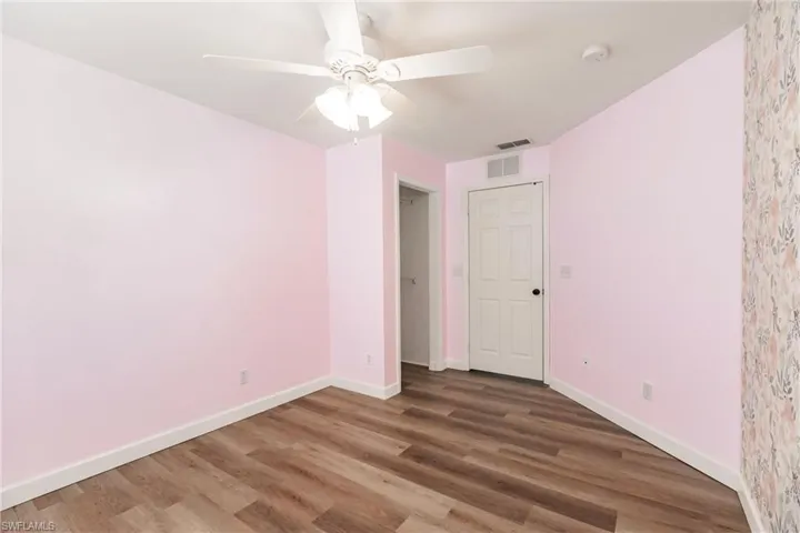 Empty room with wood-type flooring and ceiling fan