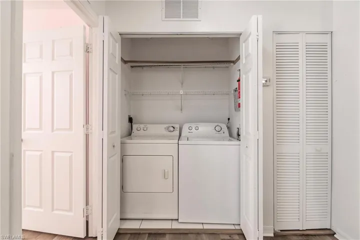 Laundry area featuring light hardwood / wood-style floors and washing machine and dryer