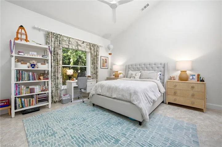 Vaulted ceiling with a ceiling fan, large window with drapes, and a secret treehouse in closet