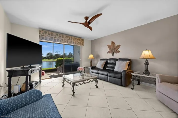 Living room featuring light tile patterned floors and a ceiling fan