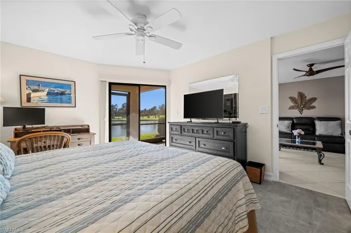 Carpeted bedroom featuring access to outside and ceiling fan