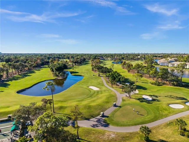 Aerial view of residential area featuring a nearby body of water and a golf club