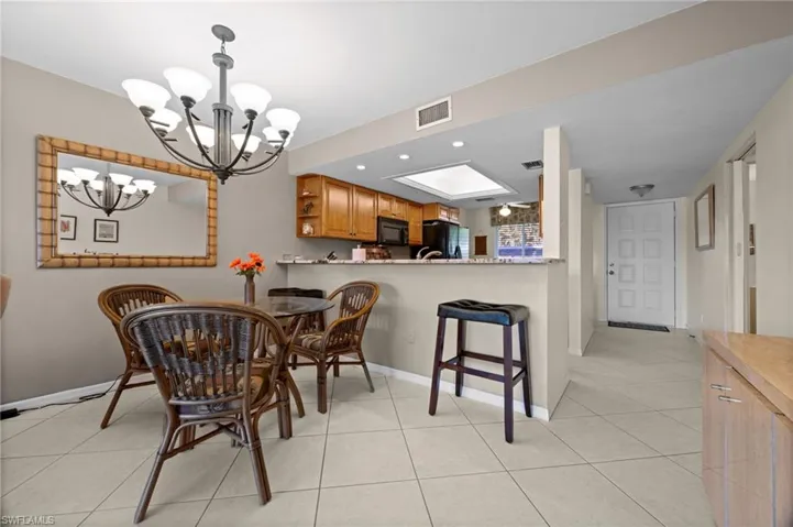 Dining room featuring light tile patterned floors, recessed lighting, and a chandelier