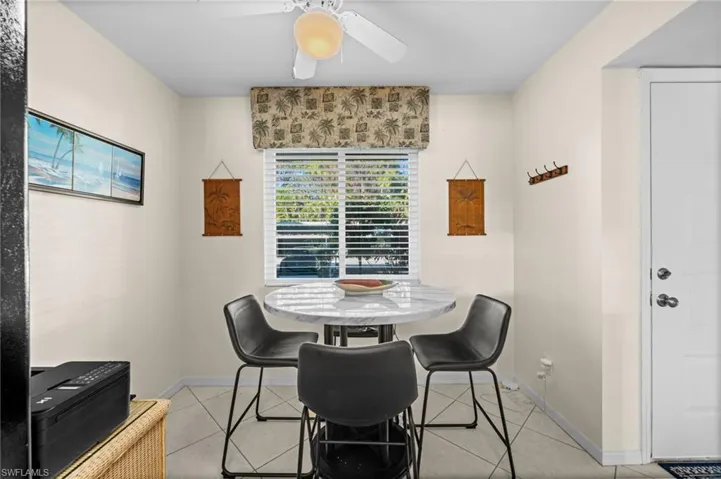 Dining room with light tile patterned floors and a ceiling fan