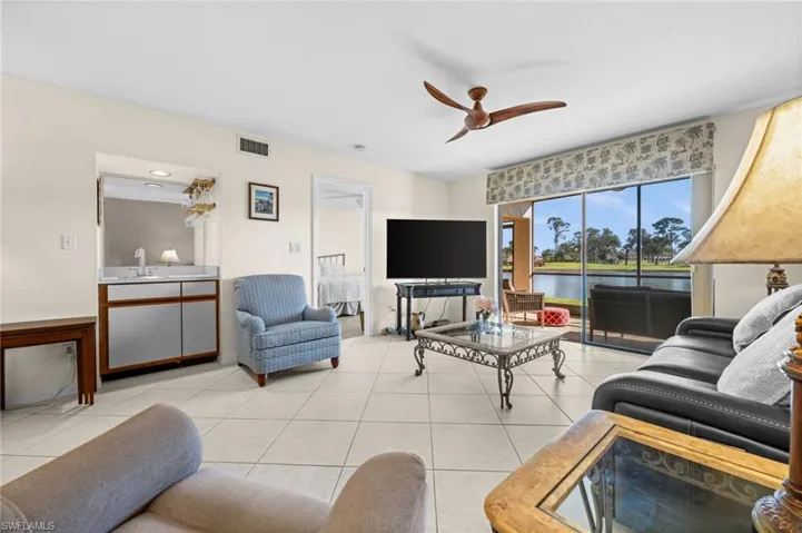 Living area featuring ceiling fan and light tile patterned floors