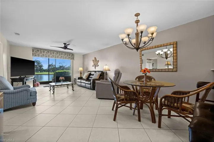 Dining room featuring a chandelier, ceiling fan, and light tile patterned floors