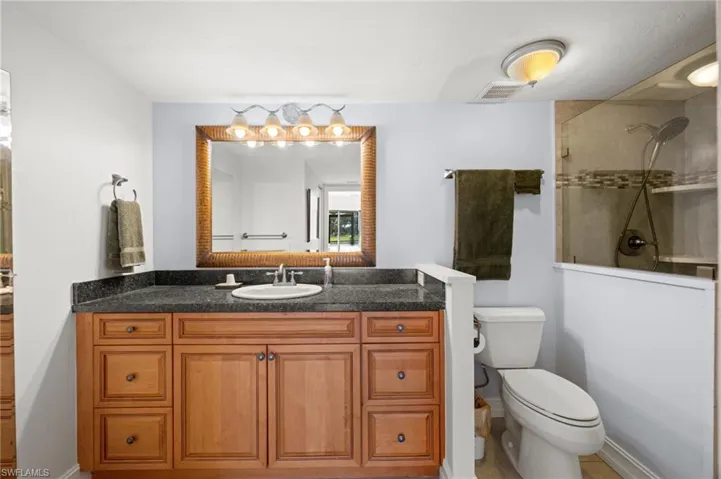Bathroom featuring a walk in shower and vanity