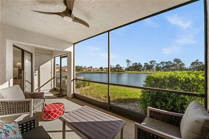 Sunroom / solarium featuring ceiling fan and a water view