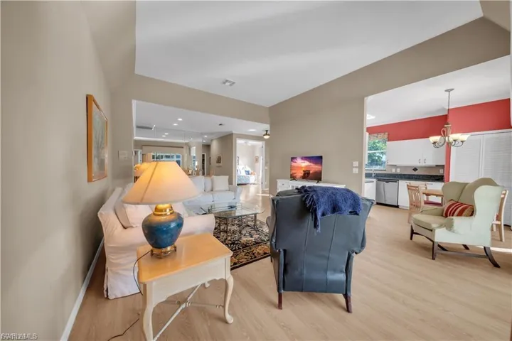 Living area with suspended lighting and light wood finished floors