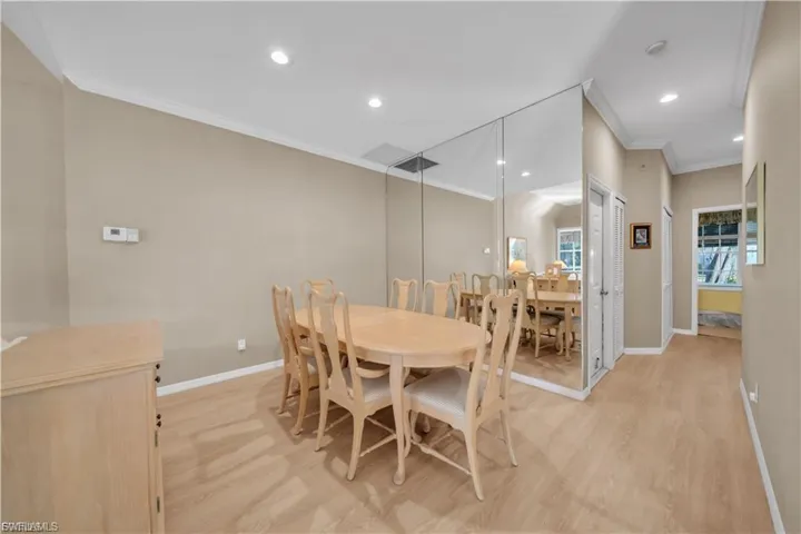 Dining room featuring crown molding, light wood-style flooring, and recessed lighting