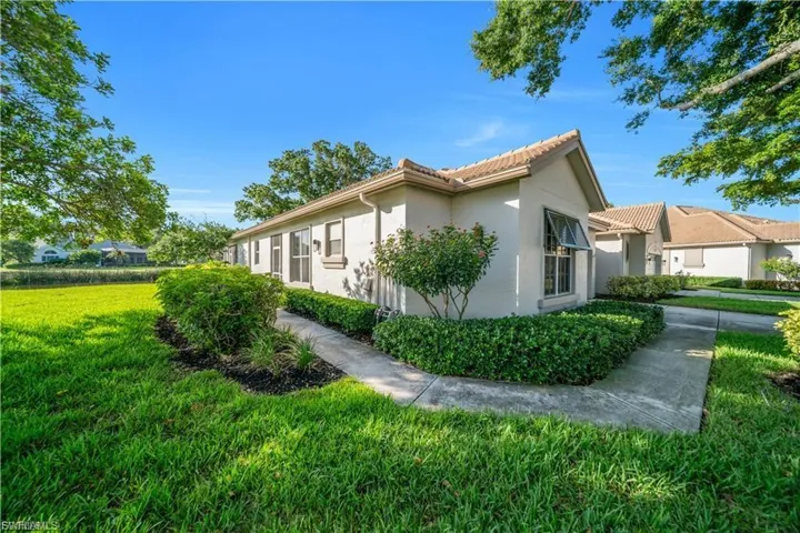 View of home's exterior featuring stucco siding, a lawn, and a tiled roof