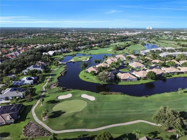 Aerial view of residential area featuring a golf club and a nearby body of water