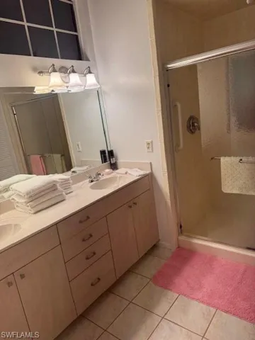Bathroom featuring vanity, an enclosed shower, and tile patterned flooring