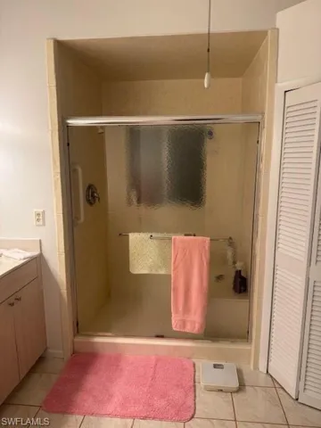 Bathroom featuring vanity, tile patterned floors, and an enclosed shower