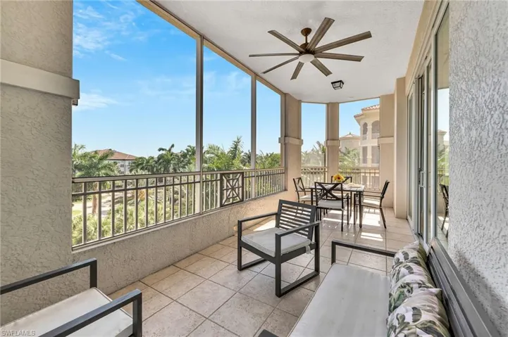Expansive screened balcony featuring a ceiling fan, recessed lighting, and tile flooring