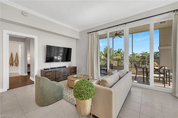 Living area featuring light tile flooring and crown molding