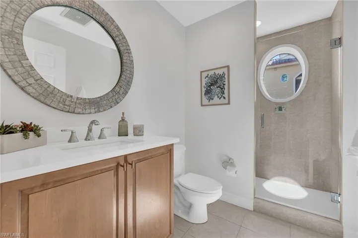 Bathroom featuring a wood-finish vanity with a white countertop and integrated sink