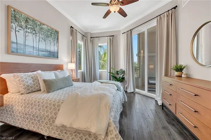 Bedroom featuring wood-finish flooring, a ceiling fan with light fixture, crown molding, and direct access to an outdoor area via sliding glass doors