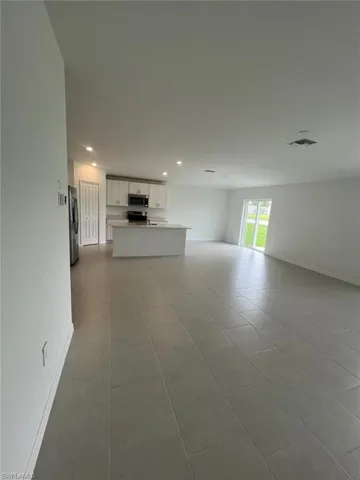 Unfurnished living room with light tile patterned floors and recessed lighting