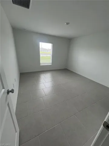 Empty room with light tile patterned floors and baseboards