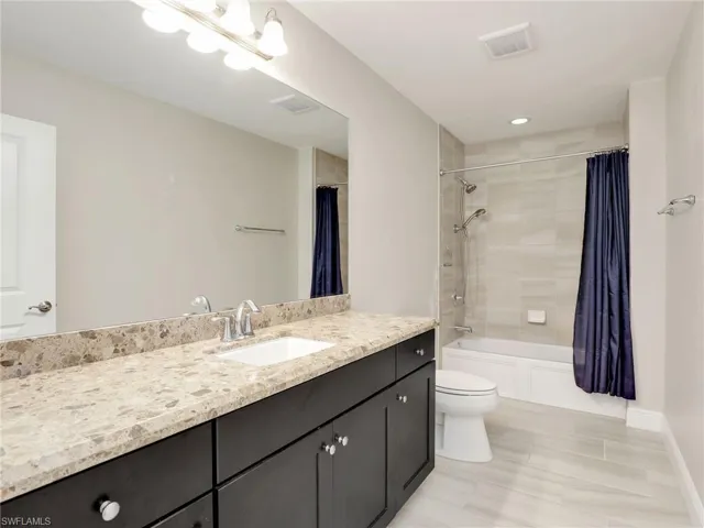 Guest Bathroom With Quartz Countertops & Tiled Tub/Shower Combo