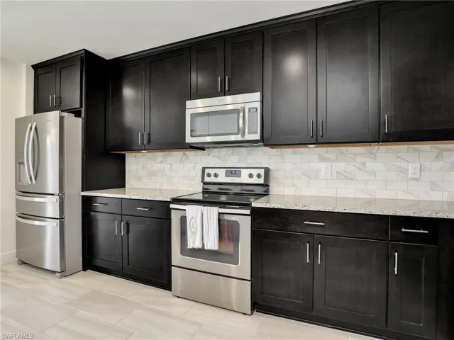 Kitchen With Granite Counters, Stainless Steel Whirlpool Appliances & Tile Backsplash