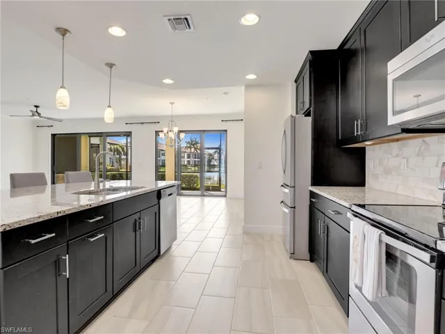 Kitchen Overlooking The Dining & Living Areas With Sliders Behind To The Lanai