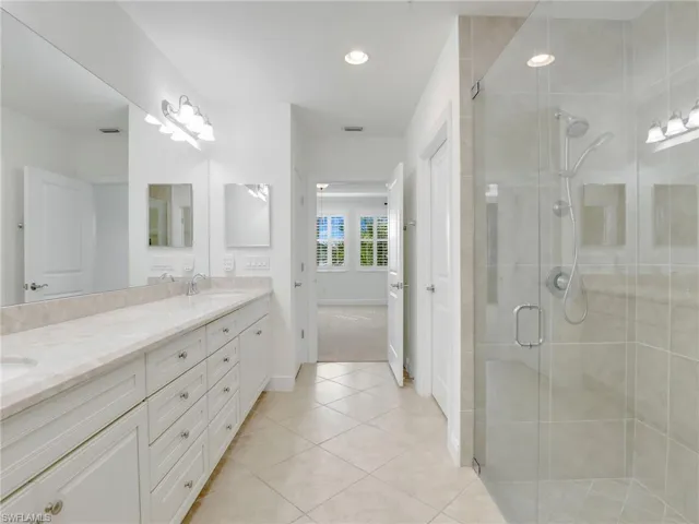 Primary Bathroom With Quartz Counters, Oversized Vanity With Drawer Bank, Linen Closet, Separate Toilet Closet & Walk In Tiled Shower With Niche & Glass Shower Enclosure