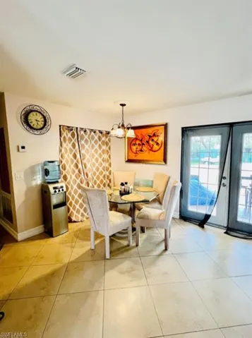 Dining area with light tile patterned flooring and a chandelier