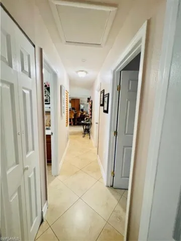 Hall with light tile patterned floors and attic access