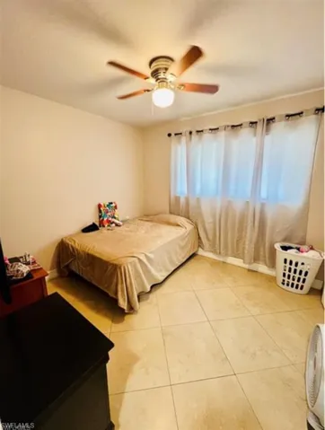 Bedroom with a ceiling fan and light tile patterned floors