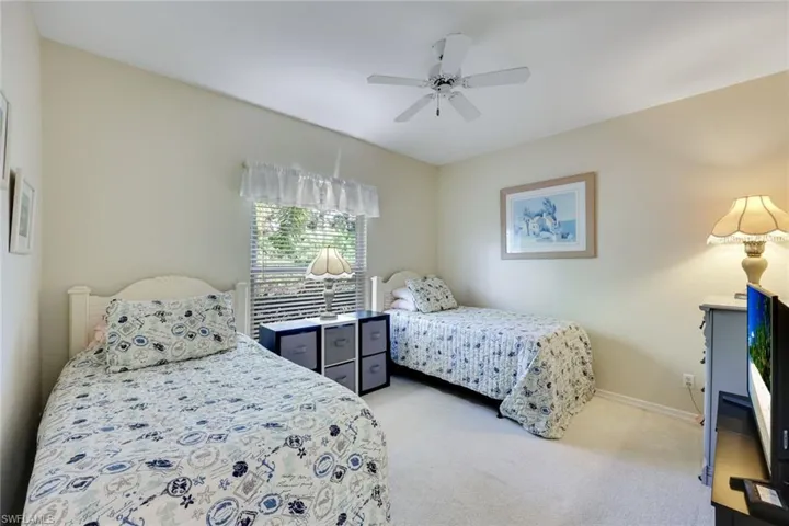 Carpeted bedroom featuring a ceiling fan and baseboards