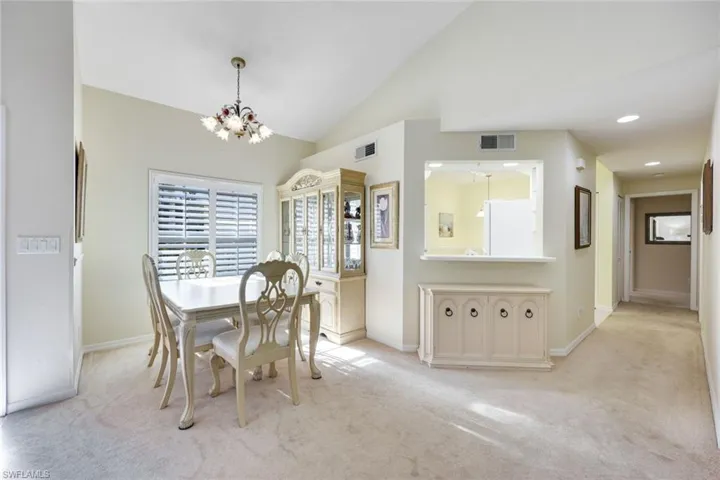 Dining area with light carpet, and a chandelier