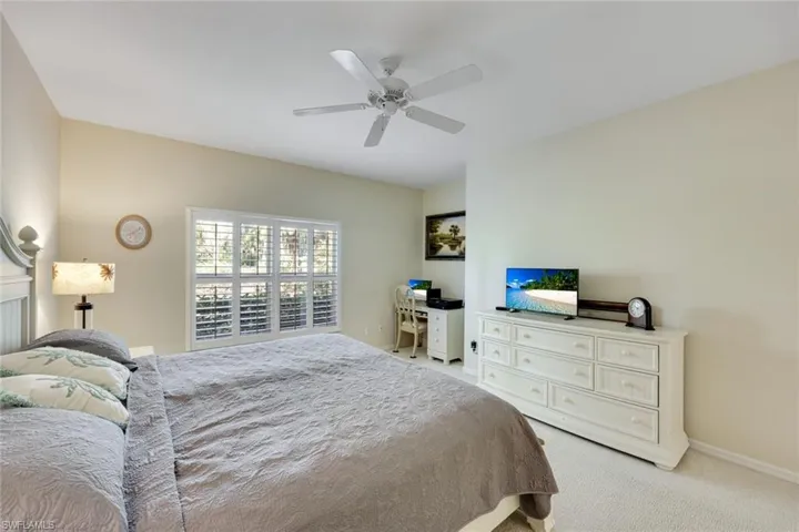 Bedroom featuring light carpet, a ceiling fan.