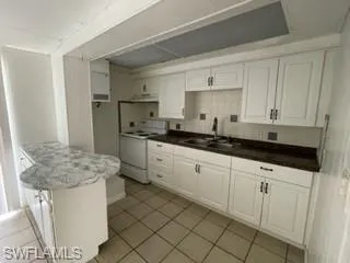 Kitchen with white cabinetry, white range with electric cooktop, sink, and decorative backsplash