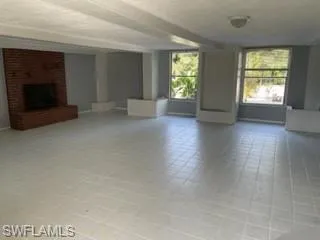 Unfurnished living room featuring a fireplace and a wealth of natural light