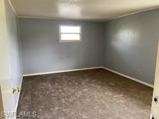 Carpeted spare room with a textured ceiling