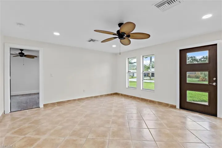 Entrance foyer with ceiling fan and light tile patterned floors