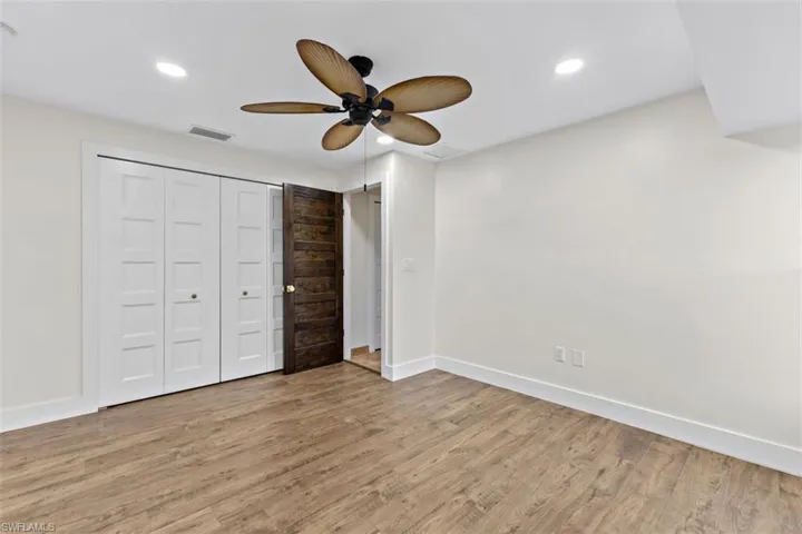 Unfurnished bedroom with wood-type flooring, a closet, and ceiling fan