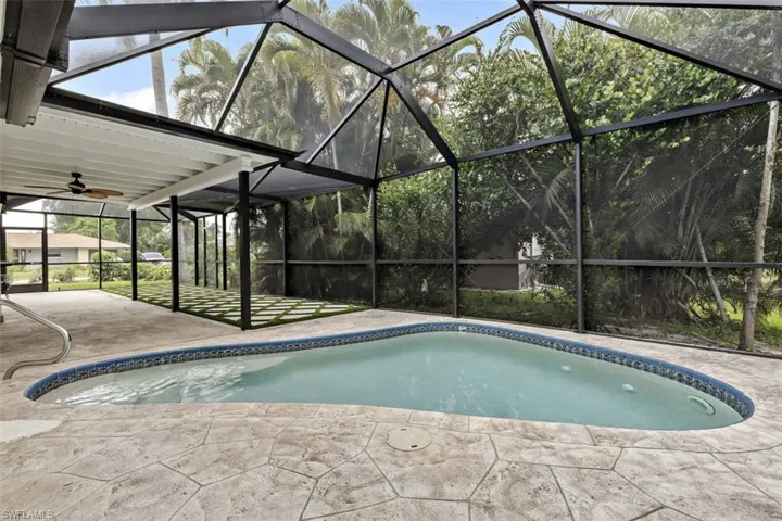 View of swimming pool with a lanai, a patio area, and ceiling fan
