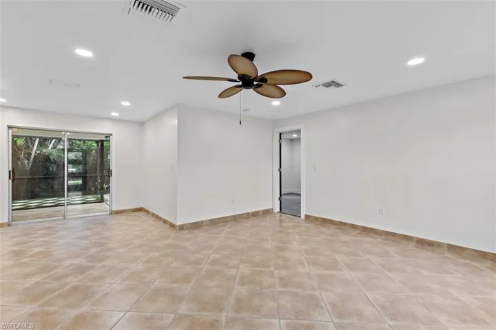 Tiled spare room featuring ceiling fan