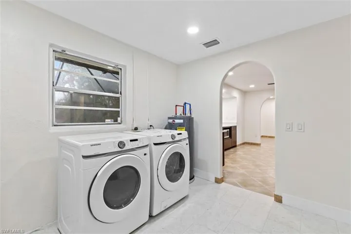 Laundry room featuring light tile patterned flooring and washing machine and dryer