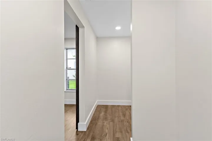 Corridor with hardwood / wood-style flooring