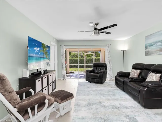Living area featuring a ceiling fan and baseboards