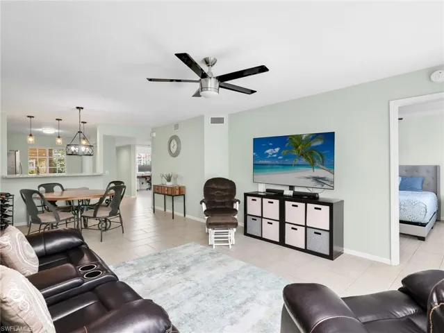 Living area with a ceiling fan and light tile patterned flooring