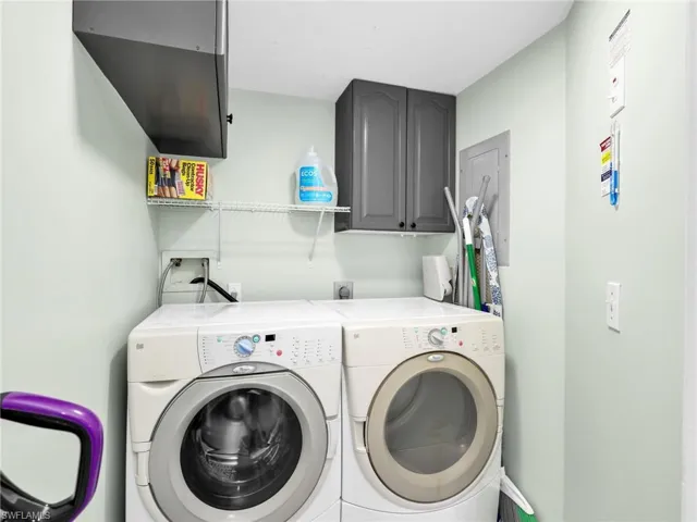 Laundry room featuring cabinet space, separate washer and dryer, and electric panel